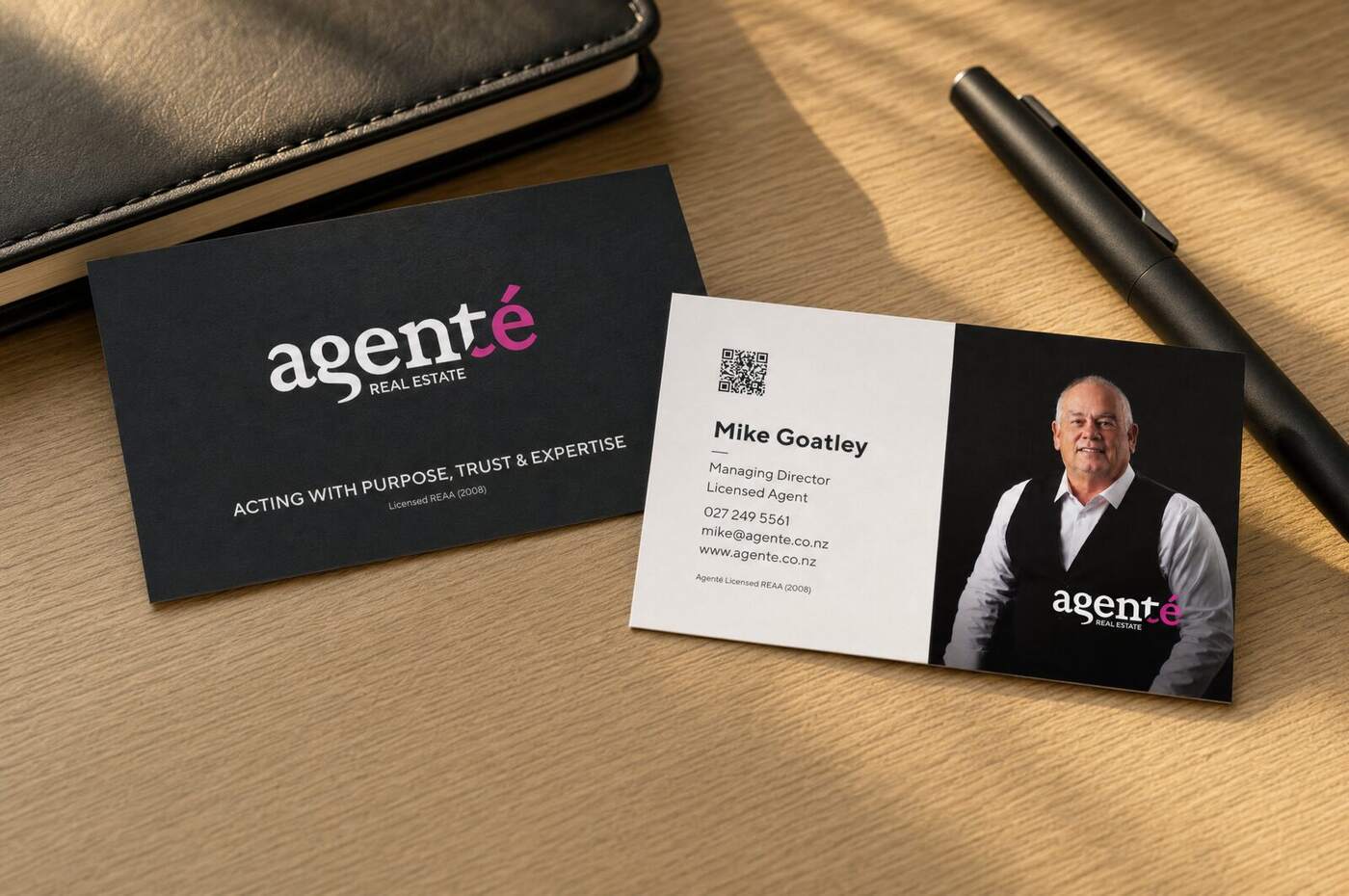 Agenté business cards on a desk — dark and light variants with agent portrait